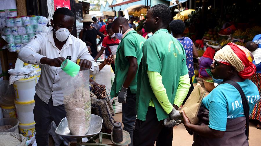 17.mar.2020 - Comerciante usa máscara enquanto serve cliente em Kimironko, mercado em Kigali, capital de Ruanda - Maggie Andersen/Reuters