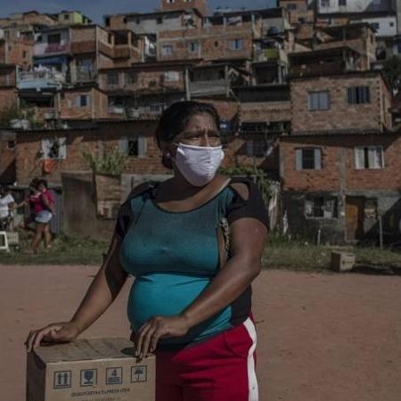 Moradora de favela usa máscara na pandemia - Victor Moriyama / Bloomberg