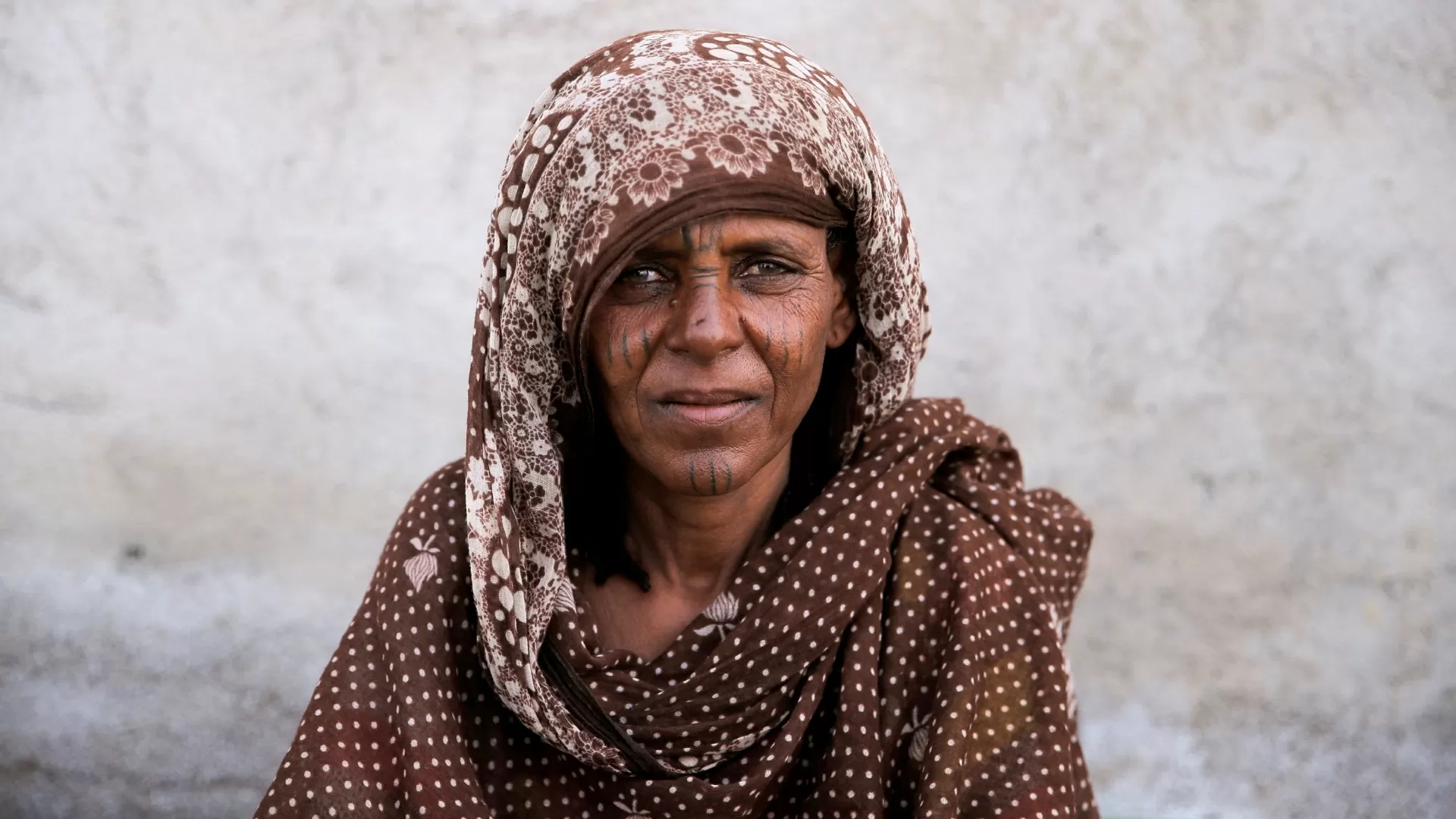 Amina Mohammed, 60, posa para uma foto em um campo improvisado para deslocados de guerra