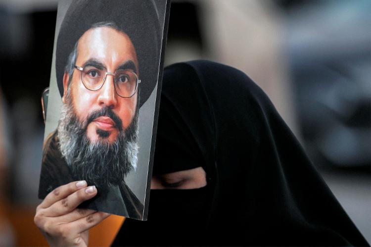 Mulher em Bagdá segura imagem de Hassan Nasrallah, líder do Hezbollah morto em ataque de Israel