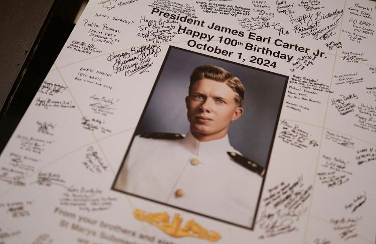 Foto mostra cartaz de Jimmy Carter jovem com mensagens de parabéns durante evento de comemoração dos 100 anos do ex-presidente dos EUA, em outubro de 2024