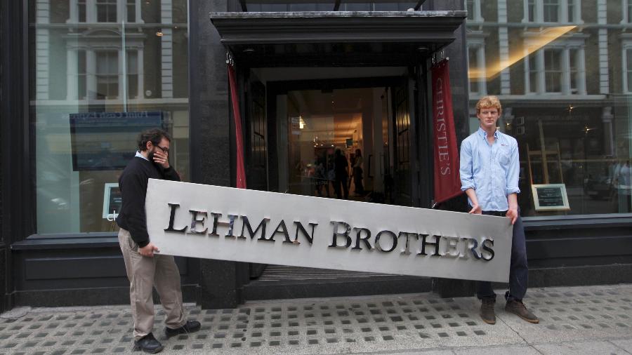 24.9.2010 - Funcionários da Christie's posam com um cartaz da Lehman Brothers na Christie's, no centro de Londres