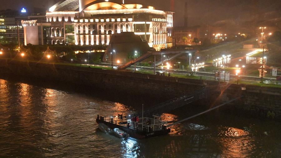 29.mai.2019 - O corpo de uma vítima coberto com plástico preto no rio Danúbio, nas proximidades do Teatro Nacional de Budapeste. Um barco com turistas naufragou nesta quarta (29). - GERGELY BESENYEI / AFP