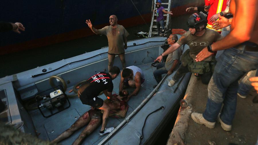 Homem ferido é socorrido após explosão perto do porto na capital libanesa Beirute, em 4 de agosto de 2020 - STR/AFP