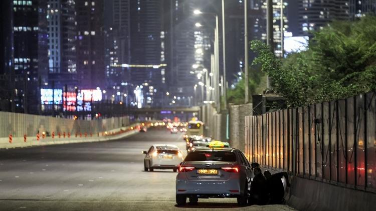 Pessoa se esconde atrás de carro enquanto Tel Aviv é atacada