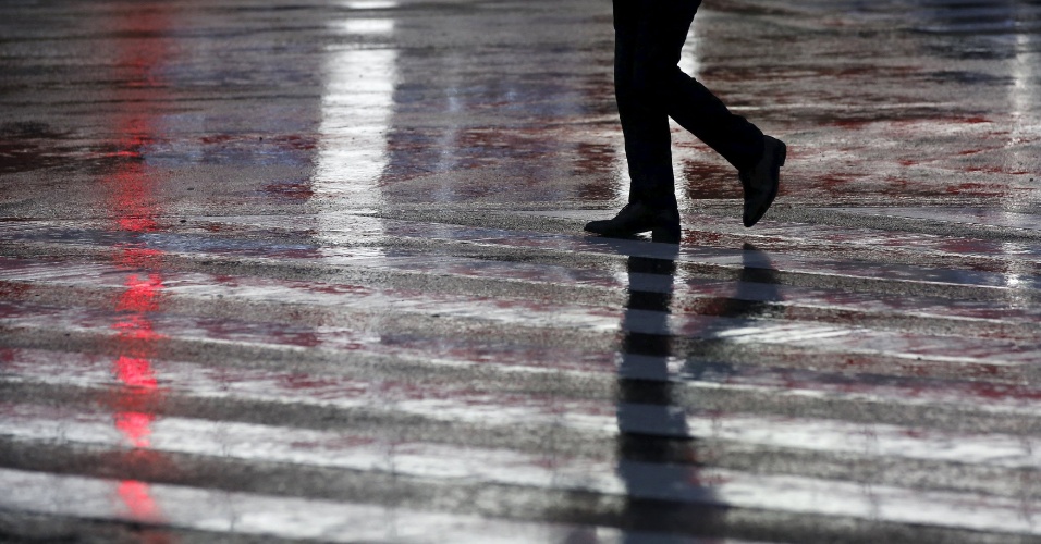 9.set.2015 - Homem caminha em meio a chuva causada pelo tufão Etau, em Tóquio, no Japão