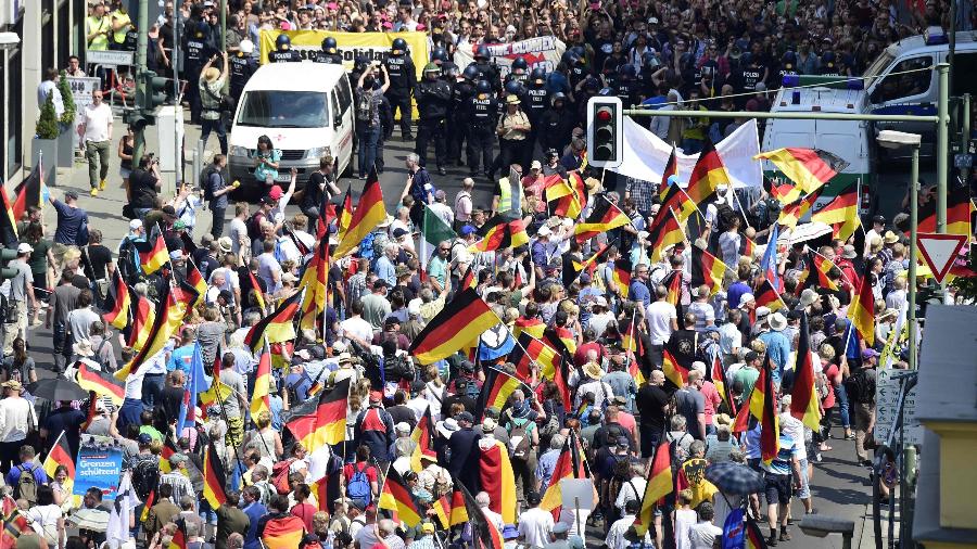 27.mai.2018 - Manifestantes erguem bandeiras e cartazes durante protesto "pelo futuro da Alemanha", organizado pela extrema-direita  - Tobias Schwarz/AFP