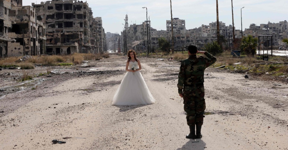 6.fev,2016 - Os recém-casados Nada Merhi, 18, e Hassan Youssef, 27, recebem instruções do fotógrafo Jafar Meray, em Homs, na Síria. A cidade era anteriormente um reduto rebelde - apelidado de capital da revolução, quando a luta começou em 2011 - até que as forças pró-governo a tomaram de de volta em 2014.