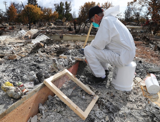 Pryor Passarino observa objeto no meio das cinzas após incêndio atingir a Califórnia - JIM WILSON/NYT