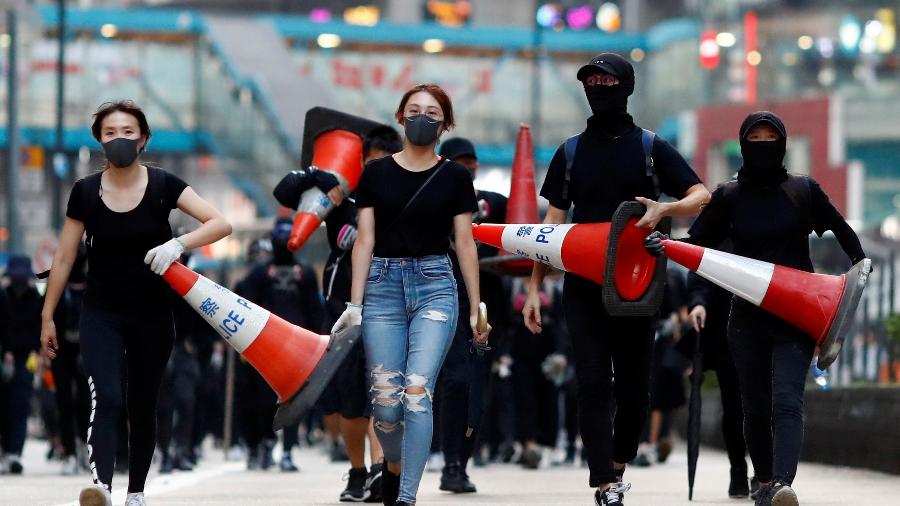 Manifestantes caminham durante protesto em Causeway Bay, área de Hino Kong conhecida pelas lojas caras - Thomas Peter/Reuters