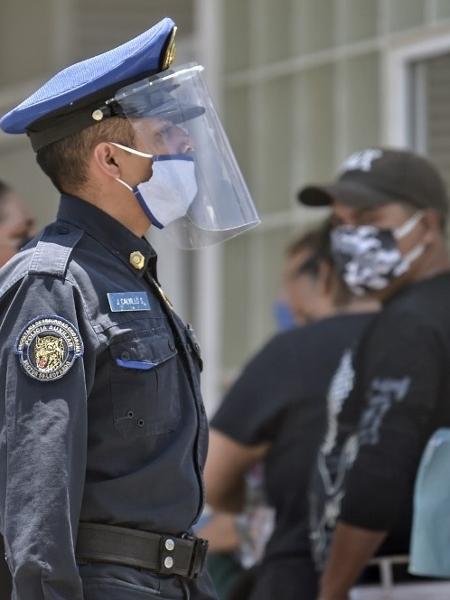 28.04.2020 - Policial vistoria fila em frente a hospital na Cidade do México - Pedro Pardo/AFP