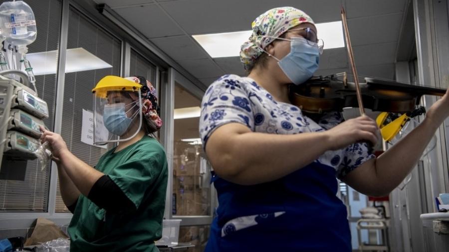 9.jul.2020 - Enfermeira chilena toca violino para pacientes infectados com o novo coronavírus no hospital El Pino, em Santiago - Martin Bernetti/AFP