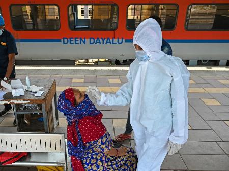 14.abr.2021 - Trabalhadora da saúde coleta amostra para teste de coronavírus de passageira em plataforma ferroviária em Mumbai, na Índia - Punit Paranjpe/AFP
