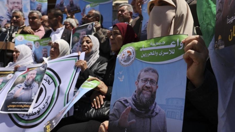 2.mai.2023 - Palestinos seguram imagem de Khader Adnan, militante que morreu após fazer greve de fome em uma prisão israelense por quase três meses - MOHAMMED ABED/AFP