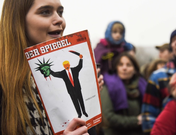 4.fev.2017 - Jovem protesta em Berlim, na Alemanha, com revista "Der Spiegel" cuja capa mostra Donald Trump com a cabeça decepada da Estátua da Liberdade - Odd Andersen/AFP