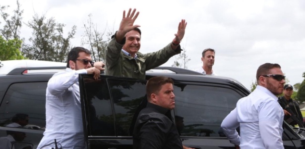 Bolsonaro com o corpo fora do carro após votar no Rio