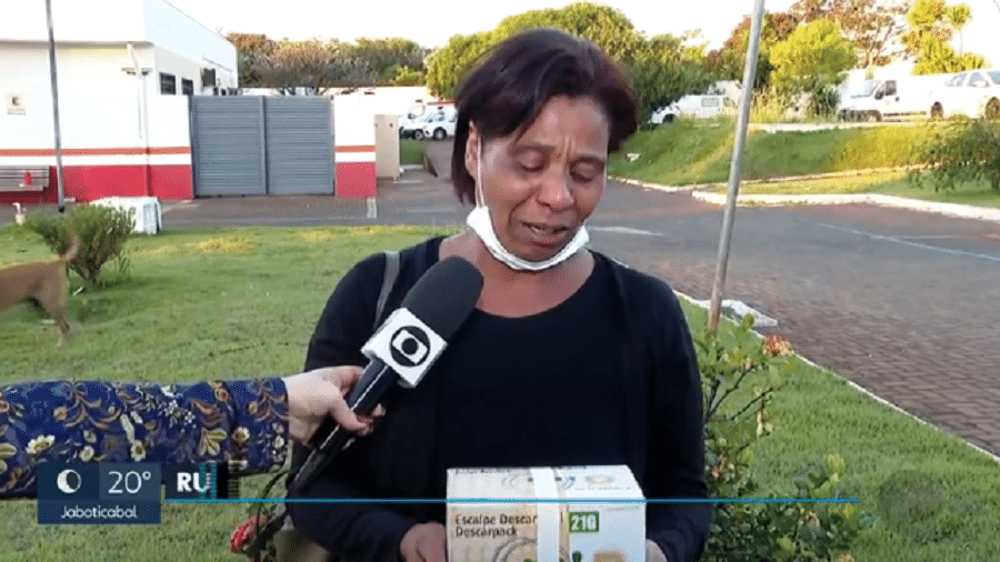 Rute Alves da Cunha, mãe da gestante, segura a caixa com o corpo do neto em Sertãozinho (SP) - Reprodução/EPTV/TV Globo