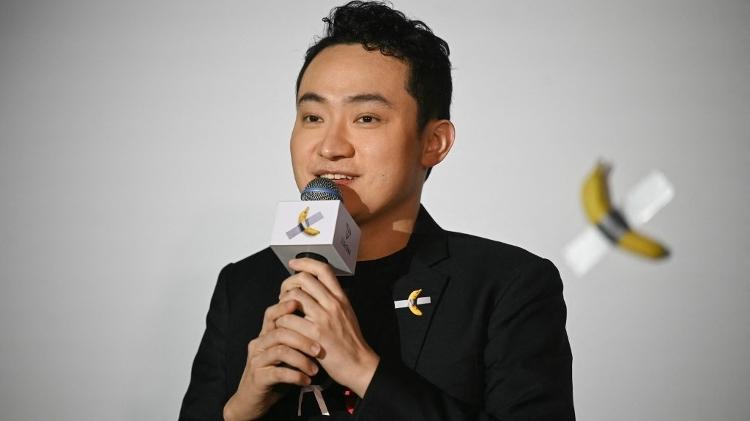 O fundador da criptomoeda nascido na China, Justin Sun, fala antes de comer uma obra de arte de banana composta por uma banana fresca presa a uma parede com fita adesiva, em Hong Kong em 29 de novembro de 2024