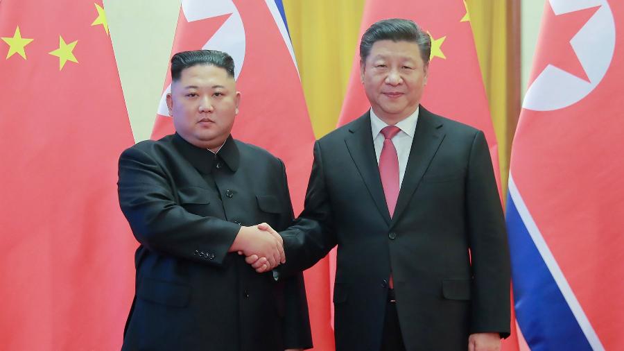 10.jan.2019 - Líder da Coreia do Norte, Kim Jong-un, aperta a mão do presidente chinês, Xi Jinping, durante visita à China - KCNA via KNS/AFP