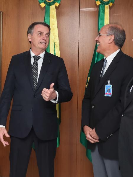 04.out.2019 - Presidente do CFM, Mauro Ribeiro (à direita), dá risada junto ao presidente Jair Bolsonaro em audiência  - Isac Nóbrega/PR