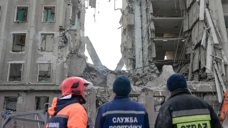 29.mar.22 - Equipes de resgate olham para os escombros do prédio do governo atingido por foguetes russos em Mykolai. - BULENT KILIC / AFP