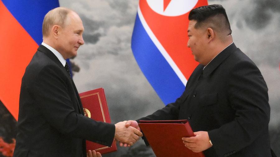 19.jun.2024 - Vladimir Putin e Kim Jong Un dão aperto de mãos após assinar acordo em Pyongyang - Kristina Kormilitsyna/Pool/AFP