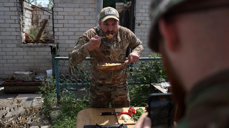 Militar e influenciador ucraniano Ruslan Mokrytskyi prova a massa que preparou para vídeo no Tik Tok na região de Donetsk, em 27 de julho de 2024