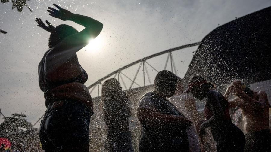 Fãs se refrescam antes de show da Taylor Swift no Rio; calor matou uma jovem - Tercio Teixeira / AFP