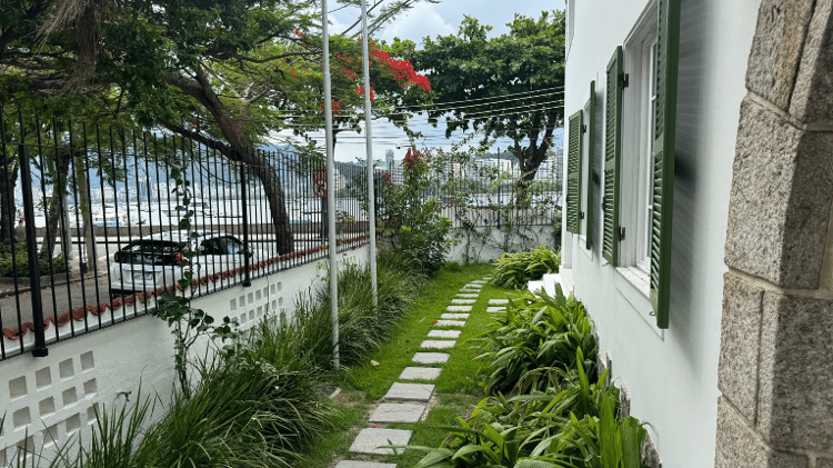 O jardim, que ocupa toda a entrada, combina com a atmosfera tranquila e arborizada da rua.