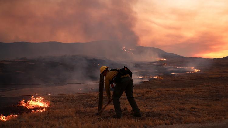Bombeiro trabalha para combater o incêndio Madre perto de New Cuyama, na Califórnia Bombeiro trabalha para combater o incêndio Madre perto de New Cuyama, na Califórnia