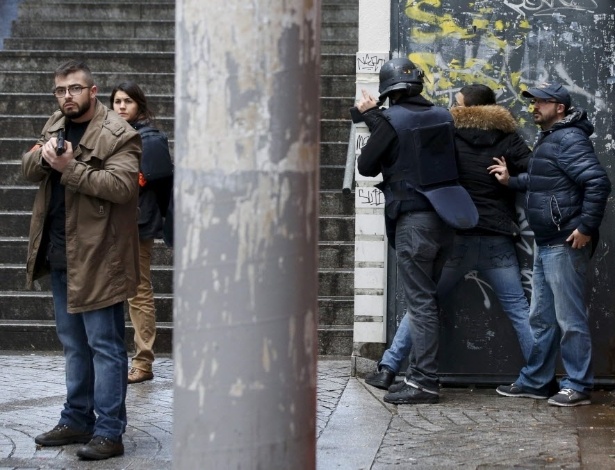7.jan.2016 - Policiais franceses revistam um pedestre enquanto patrulham área no 18º distrito de Paris (França), após um homem ser morto perto da delegacia local