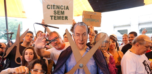 Com máscaras de Michel Temer (PMDB) e de Henrique Meirelles, manifestantes protestam contra cortes na ciência nacional -  Fabio Rossi / Agência O Globo