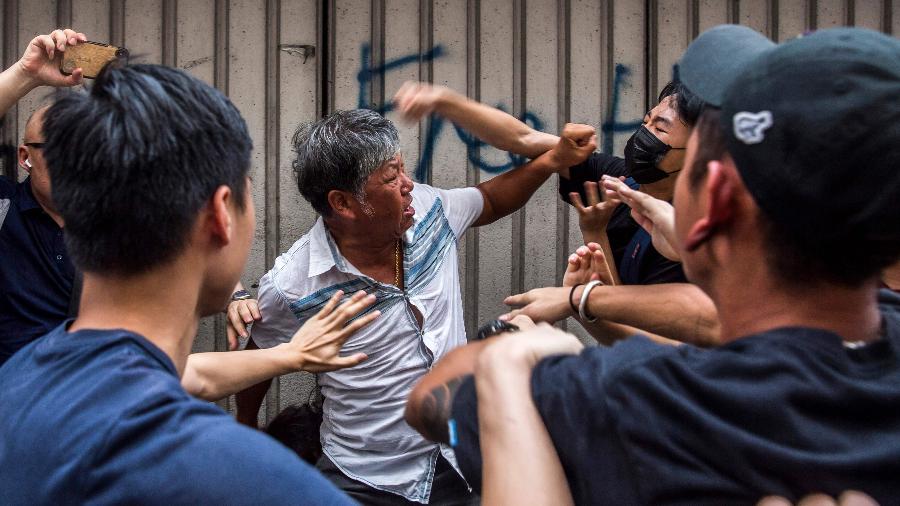 Homens brigam do lado de fora de shopping, em Hong Kong, durante protesto - Isaac Lawrence/AFP
