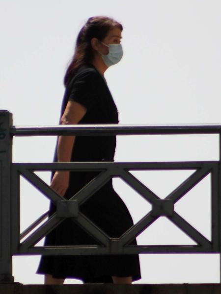 Mulher caminha utilizando máscara de proteção para o coronavírus - Willian Moreira/Futura Press/Estadão Conteúdo