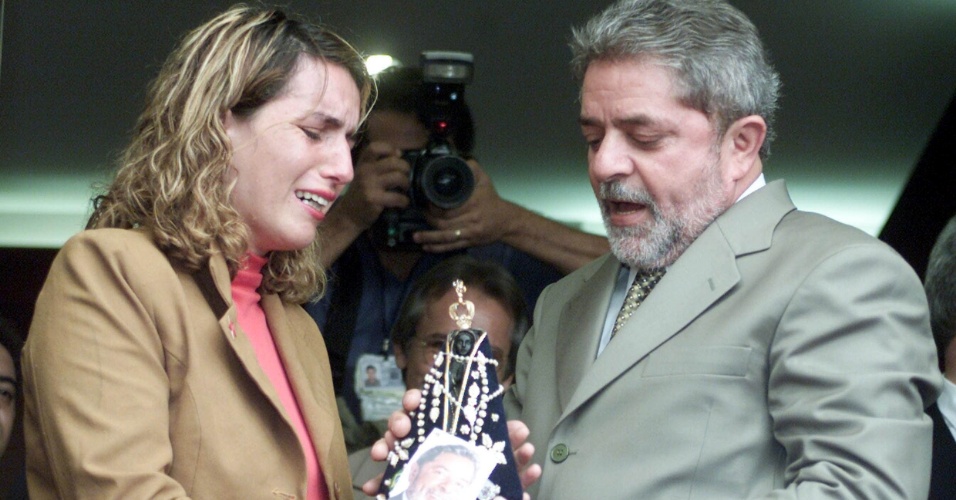 6.nov.2002 - O presidente eleito Luiz Inácio Lula da Silva recebe imagem de Nossa Senhora de Aparecida da desempregada Ieda Coelho Moura, em Brasília