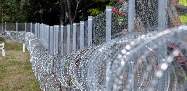 31.mai.2016 - Húngaros preparam novo trecho de cerca na vila Asotthalom, Hungria, como medida para evitar a entrada de imigrantes pela fronteira com a Sérvia - Csaba Segesvari/ AFP