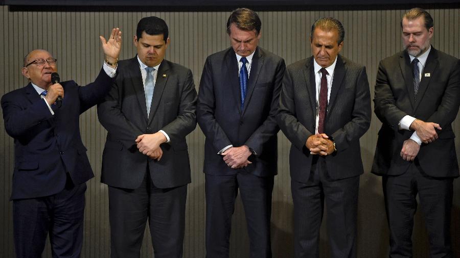 Um pastor evangélico prega ao lado de Bolsonaro, o presidente do senado, Davi Alcolumbre, o pastor Silas Malafaia e o presidente do STF, Dias Toffoli - Mauro Pimentel/AFP