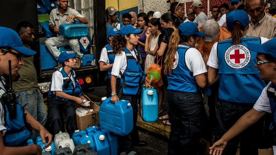 Trabalhadores da Cruz Vermelha distribuem água potável em Catia, um bairro operário de Caracas, na Venezuela - Meridith Kohut/The New York Times