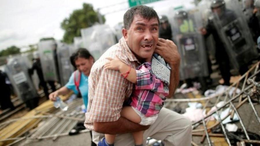Migrante hondurenho carrega criança perto do México, em outubro de 2018, em tentativa de chegar à fronteira dos EUA - Reuters