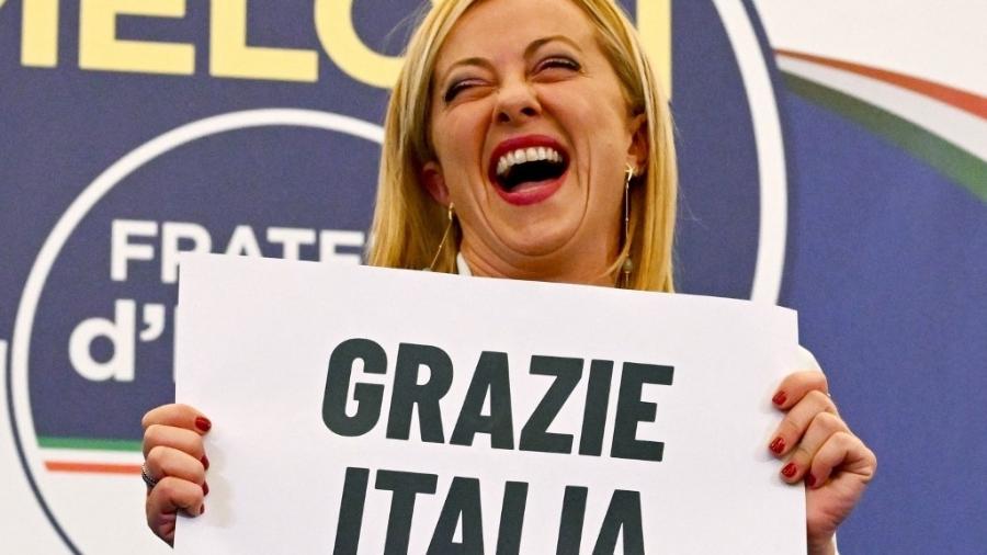 Giorgia Meloni, líder do partido de extrema-direita Irmãos da Itália segura placa com dizeres "Obrigada, Itália" após vitória do partido nas eleições parlamentares - ANDREAS SOLARO/AFP