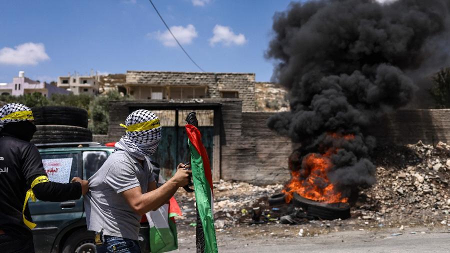 Manifestantes palestinos arremessam pedras contra soldados israelenses durante confrontos após manifestação contra a expropriação de terras palestinas por Israel na aldeia de Kfar Qaddum - Ronaldo Schemidt CHEMIDT/AFP