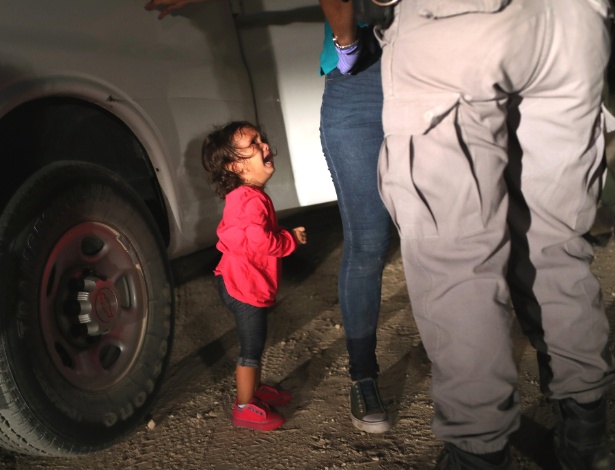 Menina de dois anos de Honduras chora enquanto sua mãe é revistada e presa em McAllen, no Texas, na fronteira entre EUA e México - John Moore/Getty Images/AFP