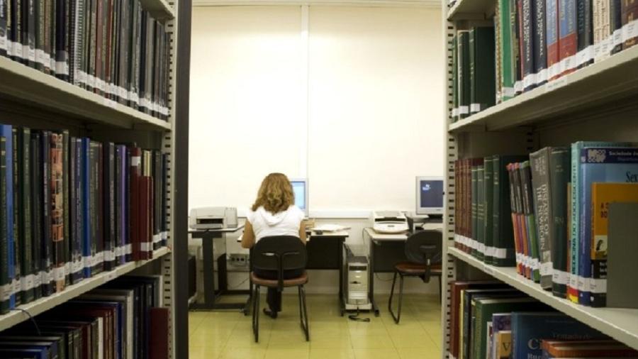 Estudante acessa computador em biblioteca na USP