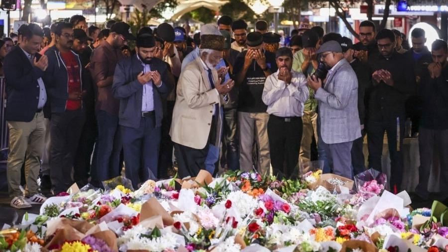 Grupo reza diante de flores oferecidas a vítimas de ataque em shopping de Sydney
