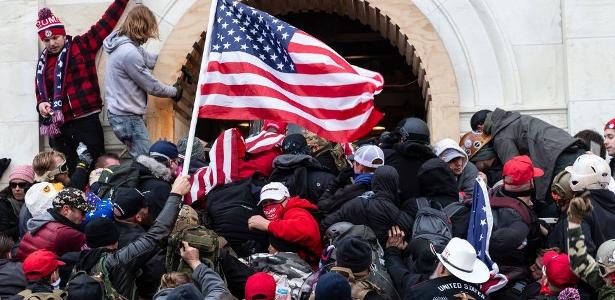 Apoiadores de Trump forçam passagem pela porta do Congresso dos EUA em 6 de janeiro de 2021