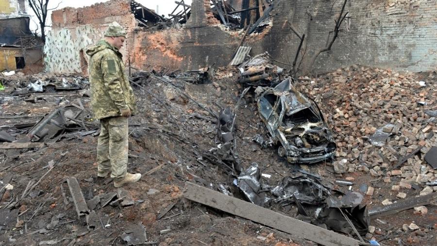 Militar ucraniano observa as destruições após um bombardeio na segunda maior cidade da Ucrânia, Kharkiv - Sergey BOBOK/ AFP
