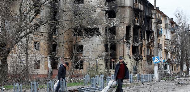 18.abr.22 - Pessoas passam por prédio residencial fortemente danificado em Mariupol, no sul da Ucrânia