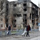 Apr 18.22 - Passers-by in front of a residential building badly damaged during the Ukraine-Russia conflict in the port city of Mariupol in the south of Ukraine - ALEXANDER ERMOCHENKO/REUTERS