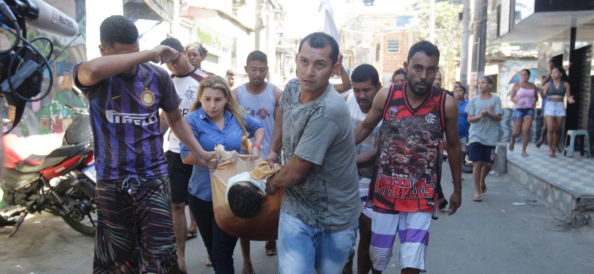 Moradores do Complexo do Alemão levam corpos e feridos para unidade de saúde - REGINALDO PIMENTA/AGÊNCIA O DIA/ESTADÃO CONTEÚDO