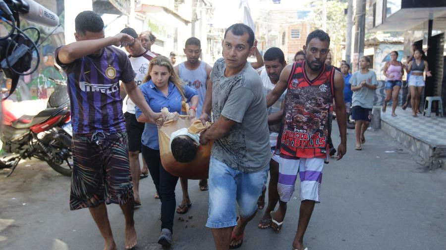 Moradores do Complexo do Alemão levam corpos e feridos para unidade de saúde após tiroteio - REGINALDO PIMENTA/AGÊNCIA O DIA/ESTADÃO CONTEÚDO